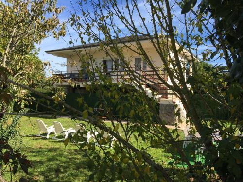 a house with two white chairs in the yard at Casa con Jardín con 2 alojamientos, con jardines no compartidos y aparcamiento privado in Noja