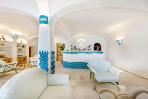 a living room with blue and white walls and chairs at Hotel Le Mimose in San Teodoro