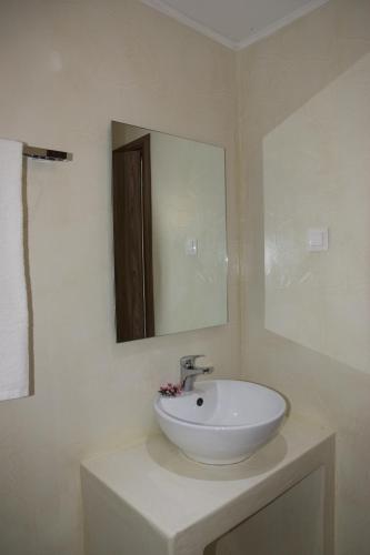 a bathroom with a white sink and a mirror at Jessica's Studios & Apartments in Kavos