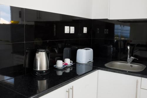 a kitchen with a black counter top with a sink at Jessica's Studios & Apartments in Kavos