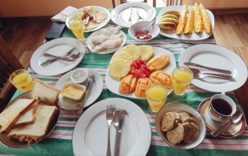 une table avec des assiettes de petit-déjeuner et des verres de jus d'orange dans l'établissement Nisadi Villa, à Bentota