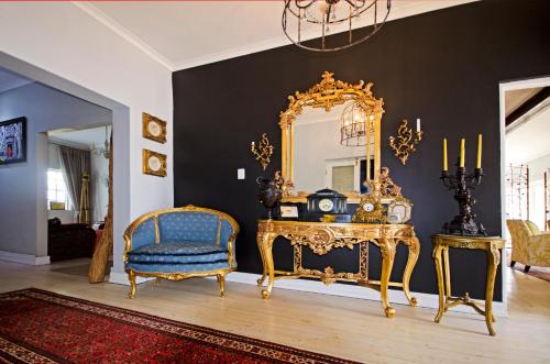 a room with a mirror and a table and a chair at Lodge on Main Guest House and Conference Centre in Port Elizabeth