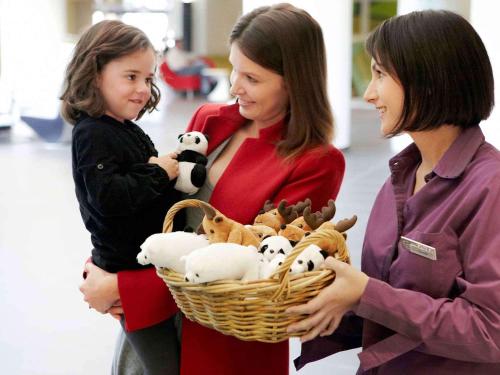 a woman and a girl holding a basket of stuffed animals at Novotel Marne-la-Vallée Noisy-le-Grand in Noisy-le-Grand