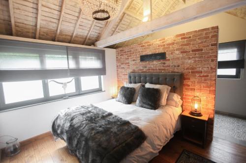 a bedroom with a brick wall and a bed at L’Al Golette in Namur