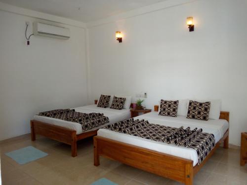 um quarto com duas camas num quarto em Hotel Gayan's em Udawalawe