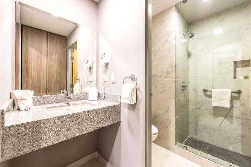uma casa de banho com um lavatório e um chuveiro em Comfort Inn Hermosillo Aeropuerto em Hermosillo
