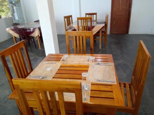 a dining room with a wooden table and chairs at Hotel Gayan's in Udawalawe