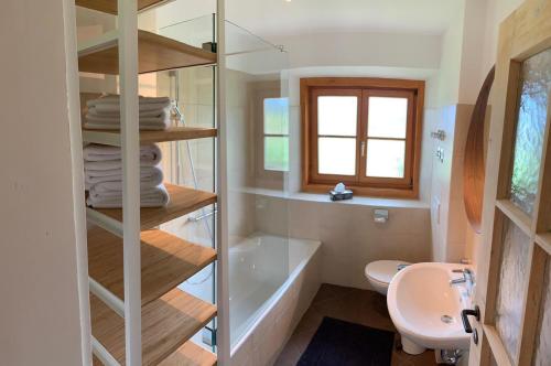 a bathroom with a tub and a toilet and a sink at ALPENRAUM Ferienwohnungen Berchtesgaden in Berchtesgaden