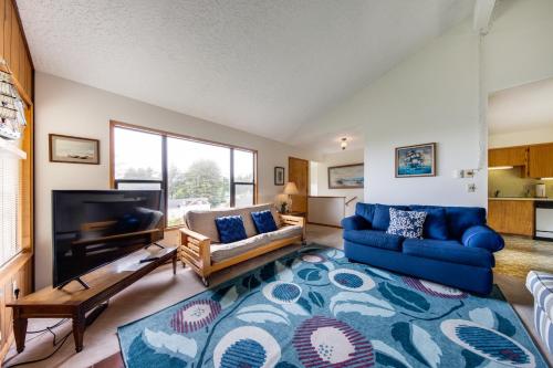 a living room with a blue couch and a tv at The Eagle's Nest in Lincoln City