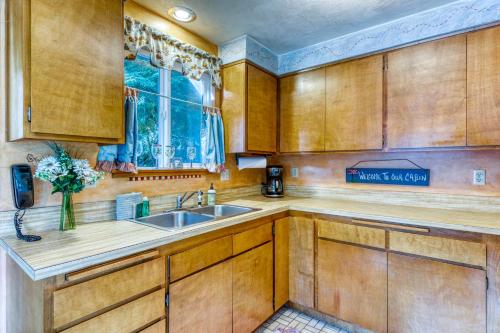 a kitchen with wooden cabinets and a sink and a window at Rustic Retreat on Mercer Lake in Florence