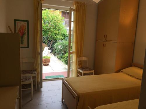 een slaapkamer met 2 bedden en een deur naar een patio bij Casa Matilde in Massa