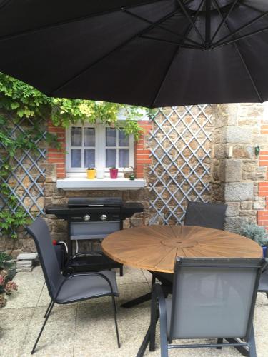 - une table et des chaises sous un parasol sur la terrasse dans l'établissement Maison *** 400m plage du sillon et thermes marins, à Saint-Malo