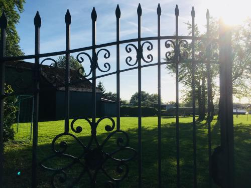 a gate to a yard with the sun behind it at Ferienhof A&B Wellness Villa 6 personen in Bullange