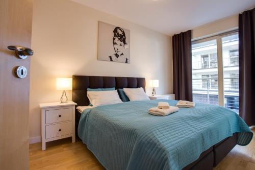 a bedroom with a bed with two towels on it at Apartamenty Tulip - visitopl in Międzyzdroje