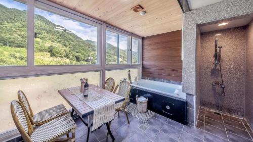a bathroom with a table and a bath tub at Mokkoji Pension in Hadong