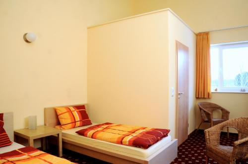 a bedroom with a bed and a desk and a window at Hotel Zug um Zug in Schemmerhofen