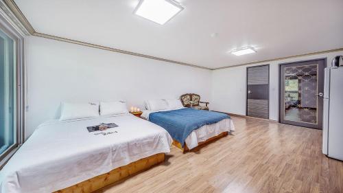 a bedroom with a large bed and a window at Mokkoji Pension in Hadong