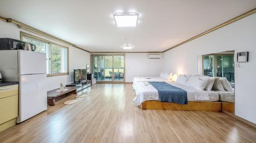a large bedroom with a large bed and a kitchen at Mokkoji Pension in Hadong