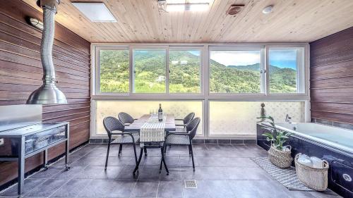 a dining room with a table and a bath tub at Mokkoji Pension in Hadong
