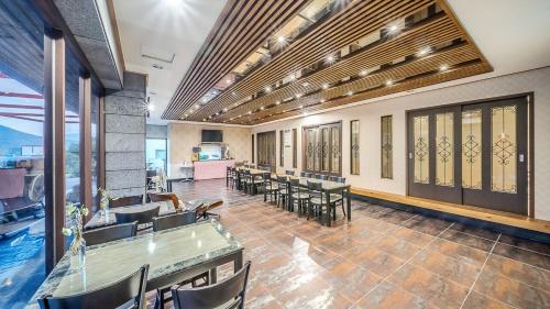 a cafeteria with tables and chairs in a room at Mokkoji Pension in Hadong