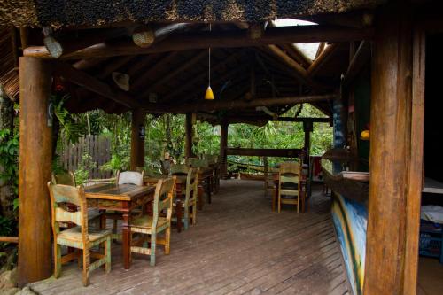 una terraza de madera con mesas y sillas de madera en Pousada Favo De Mel, en Ilha do Mel