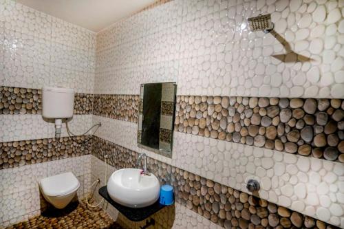 a bathroom with a sink and a toilet and a mirror at Hotel Bhakti Rajkot I Hotel in Rajkot I Best Hotel in Rajkot in Rajkot