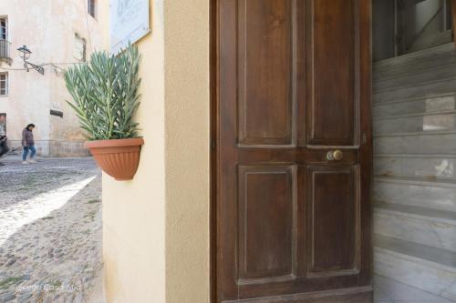 a brown door with a potted plant on the side of a building at Ottocento Guest House in Alghero