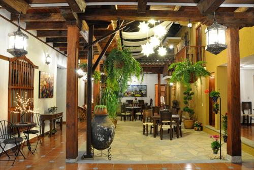 restauracja ze stołami i krzesłami oraz dużą wazą w obiekcie Casa Santa Lucia w mieście San Cristóbal de Las Casas