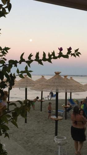 a group of people on a beach with umbrellas at Blue Sea Apartment in Torre Canne