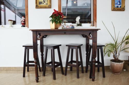 a wooden table with four bar stools under it at Pensiunea Romantic Belvedere Paltinis in Păltiniş