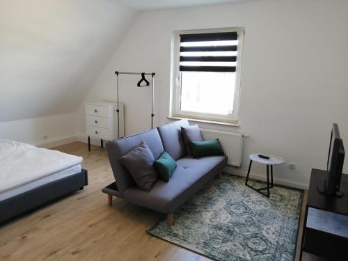 een woonkamer met een bank en een raam bij Apartment Central in Ratingen