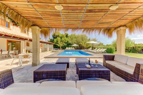 an outdoor patio with wicker furniture and a swimming pool at Villa Ponent by Sealand Villas in Pollença