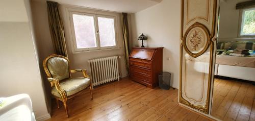 a bedroom with a chair and a dresser and a mirror at Ferienhaus Sanssouci in Stahnsdorf