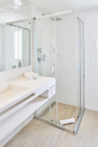 a bathroom with a glass shower and a sink at Sol Bahía Ibiza Suites in San Antonio