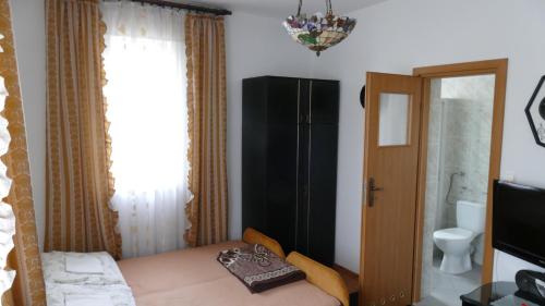 a small bedroom with a bed and a black cabinet at Willa Victoria in Ciechocinek