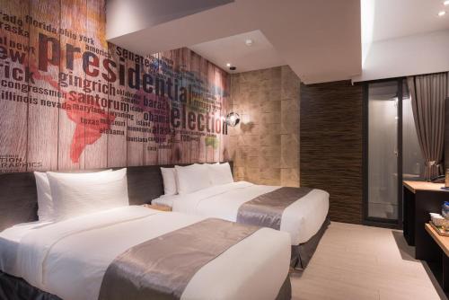 two beds in a hotel room with a wall mural at Sunrise Hotel in Chiayi City