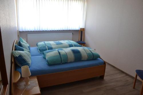 una camera da letto con un letto con lenzuola blu e una finestra di Apartment Baden Baden Haus am Ibachweg a Baden-Baden