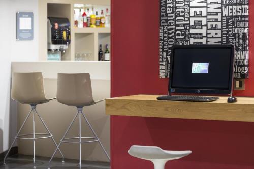 a bar with two stools and a computer on a counter at Holiday Inn Express Southwark by IHG in London