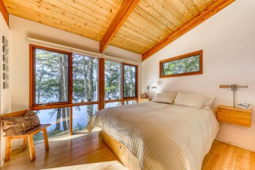 a bedroom with a bed and large windows at Lily Pond Bungalow in Edgecomb