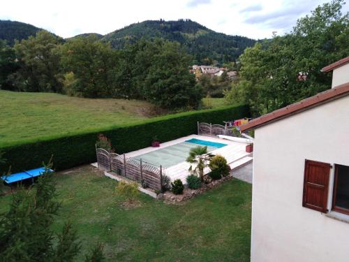 a swimming pool in a yard next to a house at Chambres des arrys in Bas-en-Basset