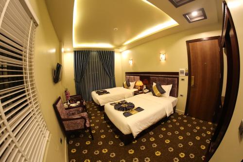 a hotel room with two beds and a window at Gallant Hotel 168 in Hai Phong