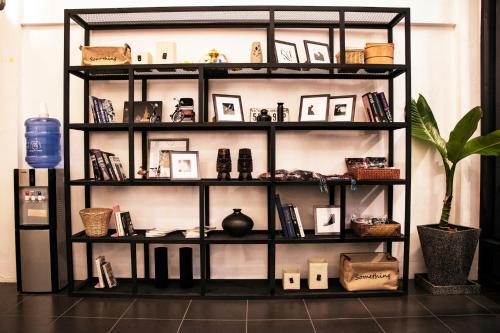 a book shelf filled with photos and a plant at Backpack Hostel in Chiang Rai