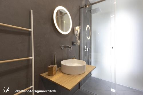 a bathroom with a sink and a glass shower at Le Dimore Degli Archi Catania in Catania