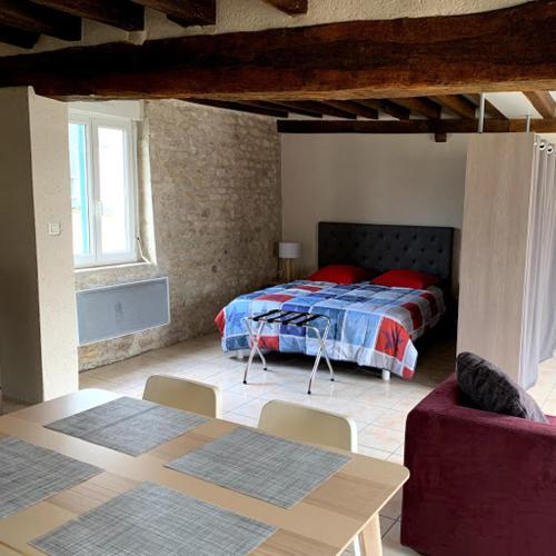 um quarto com uma cama, uma mesa e um sofá em cœur de village em La Chapelle-Onzerain