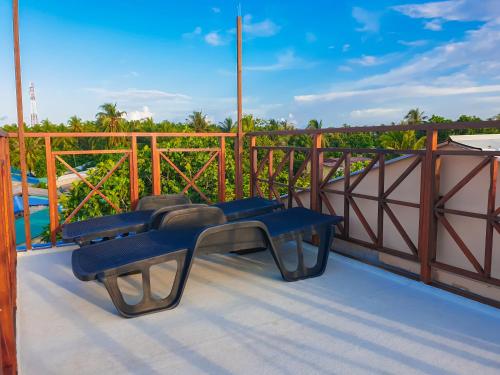 two blue chairs sitting on a balcony with a view at Nemo Inn in Omadhoo