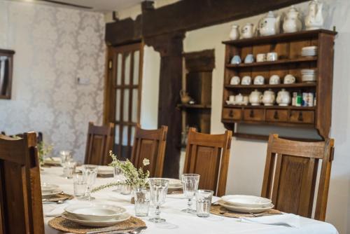 una mesa de comedor con platos y vasos. en La Gándara, en Crespo