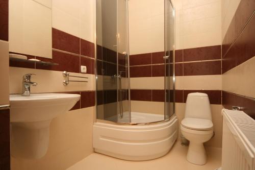 La salle de bains est pourvue de toilettes, d'un lavabo et d'une douche. dans l'établissement Гостьовий дім Tauer, à Tatariv