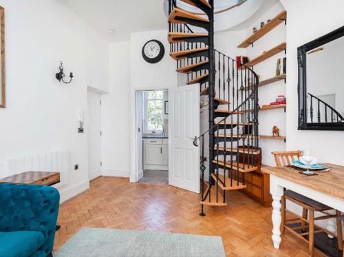 a spiral staircase in a living room with a blue couch at Warwick Post Office Apartment in Warwick