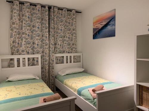two twin beds in a room with curtains at Apartamento Las Terrazas in Granadilla de Abona