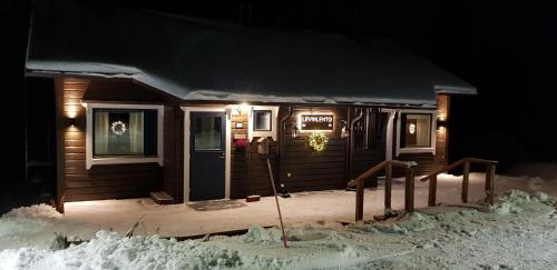 レヴィにあるLevinlentoの雪の降る夜、ポーチのある小さな家